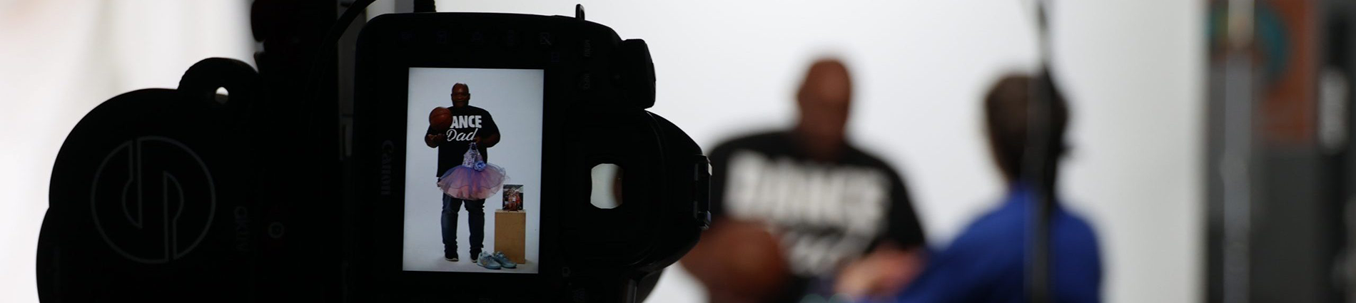 A camera screen shows a man being photographed.